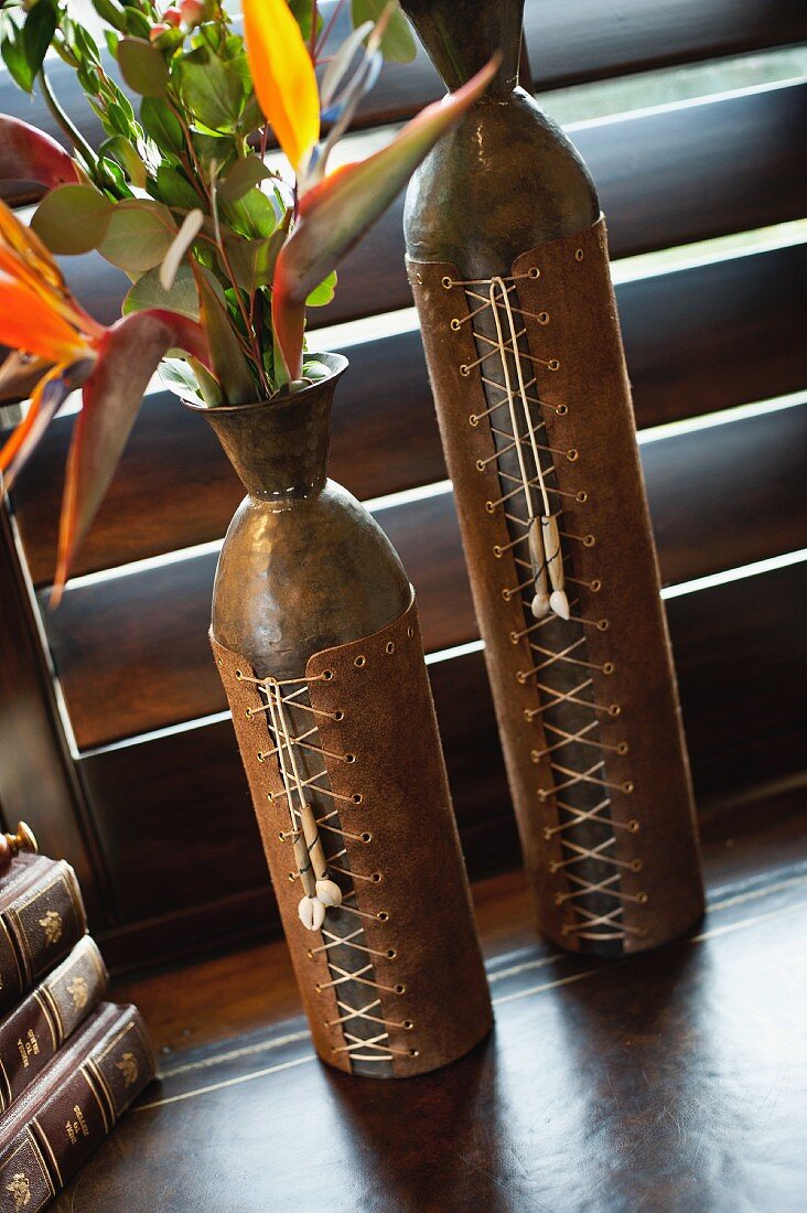 Close-up of two ornate brown vases on table
