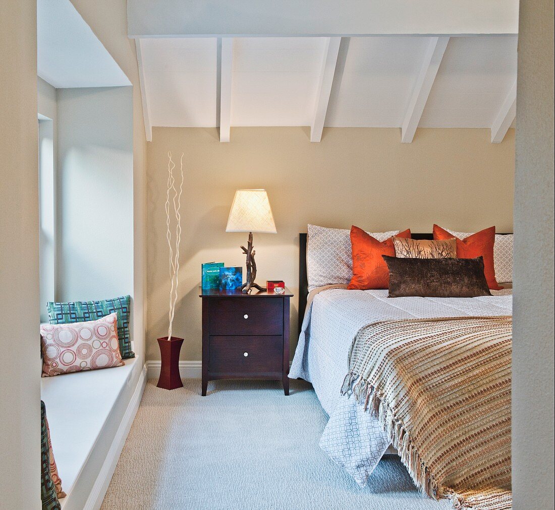 Bedroom with wooden ceiling, double bed, side table in window niche