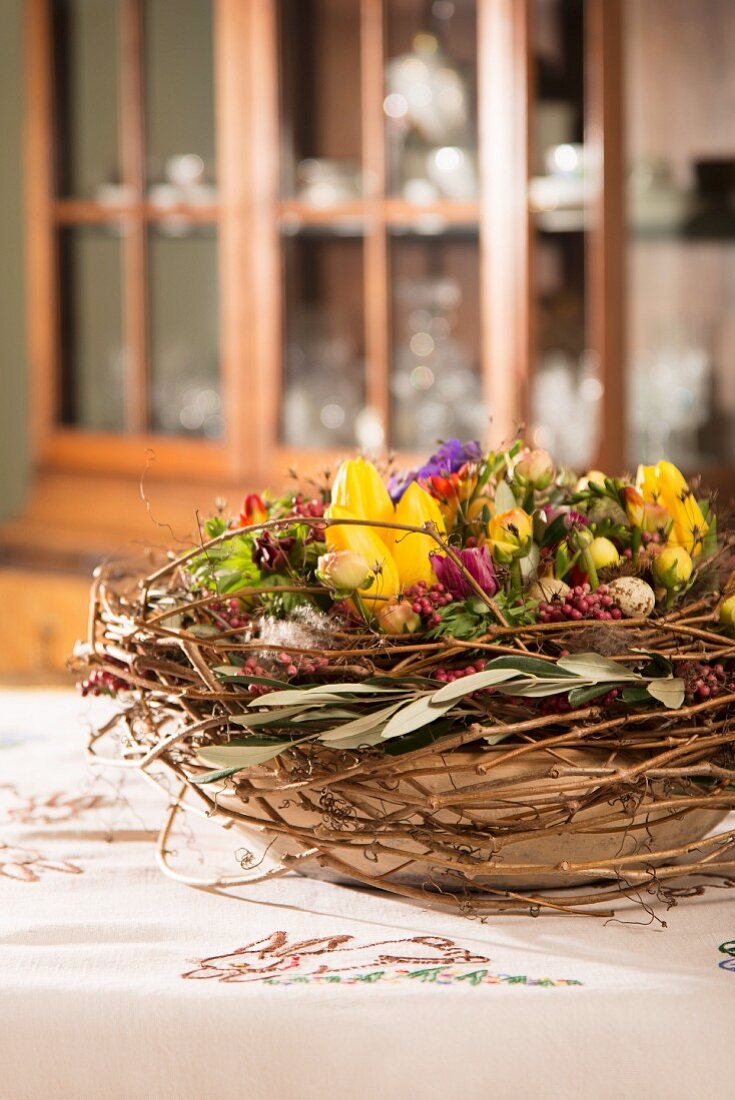 Tischdekoration für Ostern mit Frühlingsblumen & Weidenzweigen