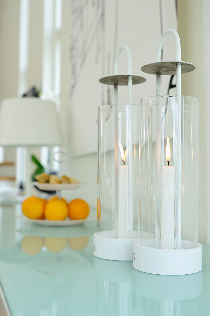 Windlichter mit zylindrischem Glasbehälter auf Glas Ablage