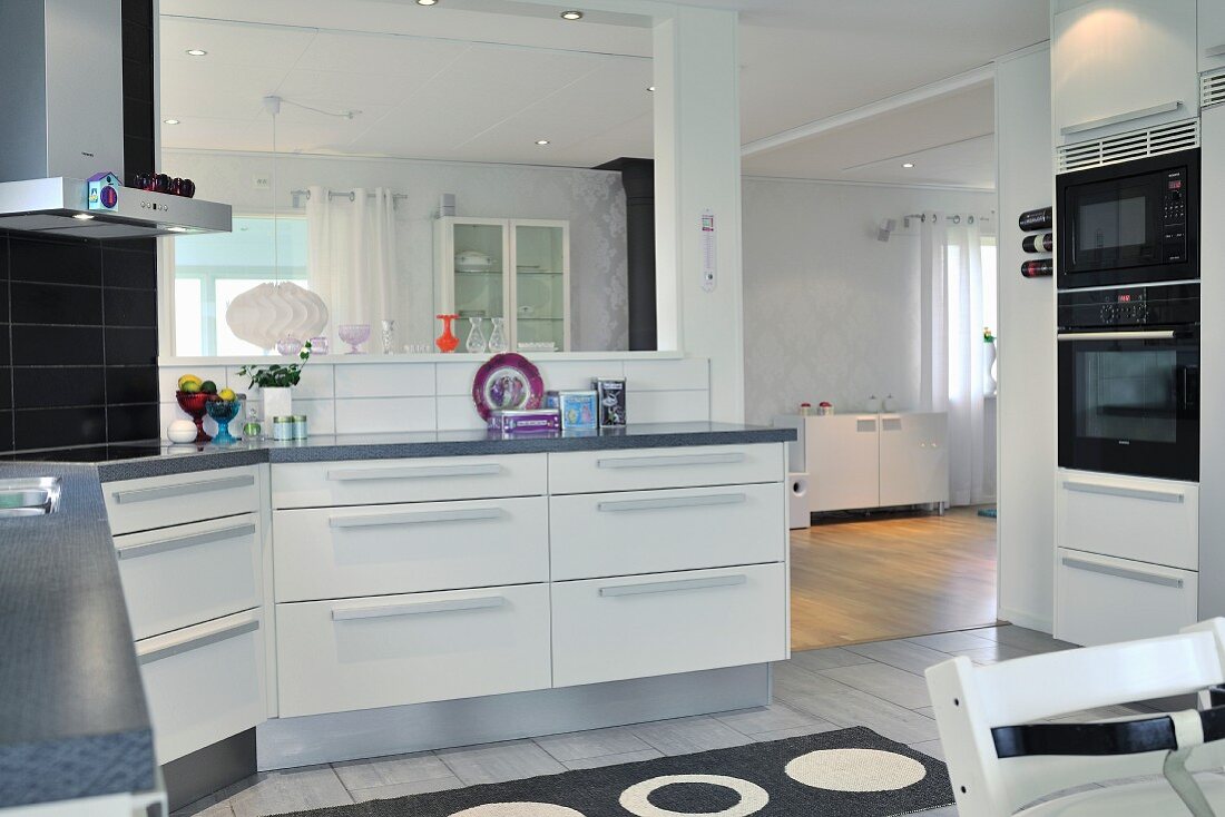 White kitchen counter in open-plan kitchen with view into living area