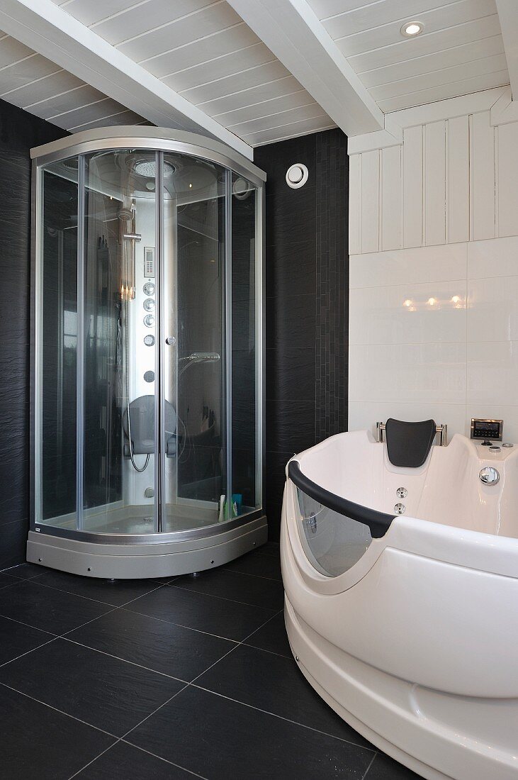 Moderne Duschkabine und Whirlpool-Wanne im schwarz-weissen Badezimmer eines skandinavischen Holzhauses