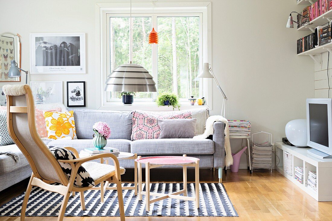 Sitzgruppe mit Überecksofa und skandinavischen Holzmöbeln in jugendlichem Wohnraum