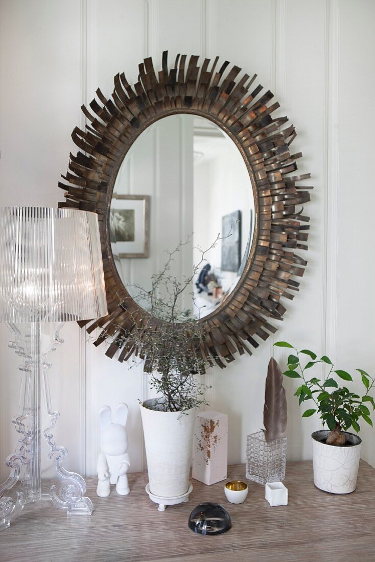 Ovaler Spiegel mit strahlenförmigem Metallrahmen, darunter Tischleuchte La Bourgie von Ferruccio Laviani auf Ablage