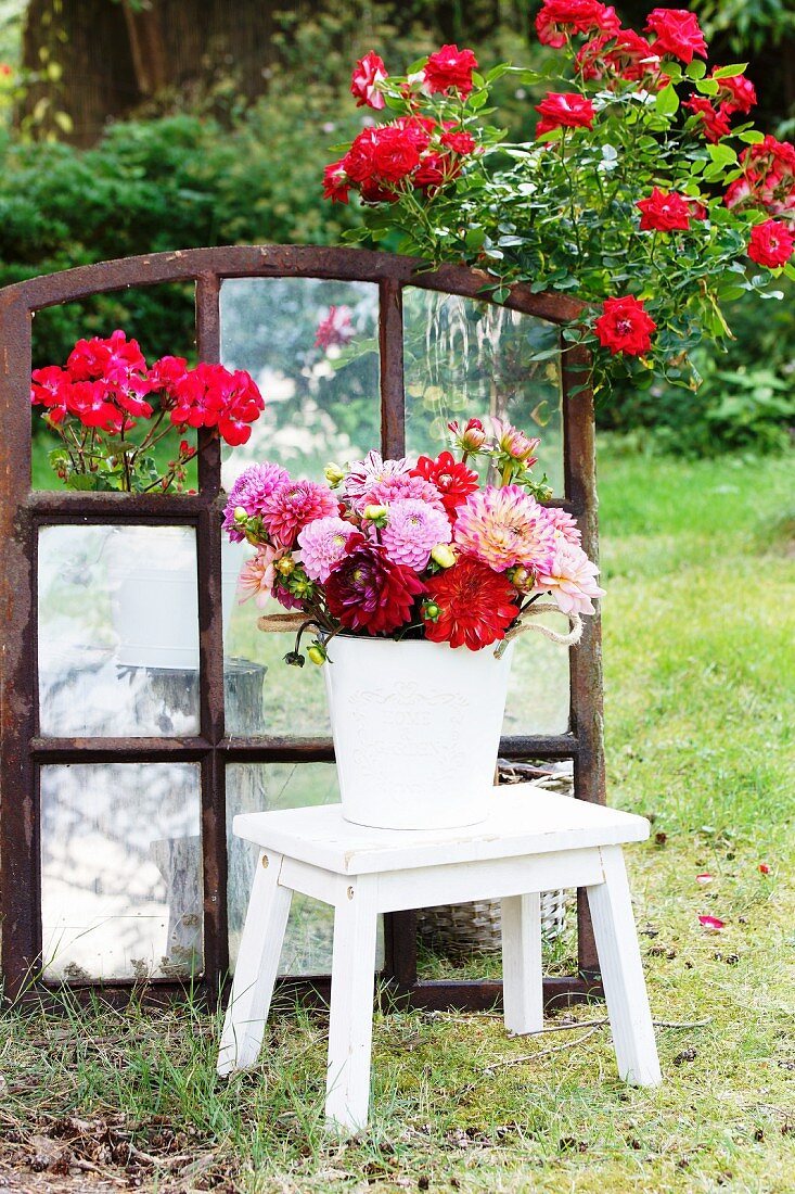 Bouquet of dahlias on stool in garden