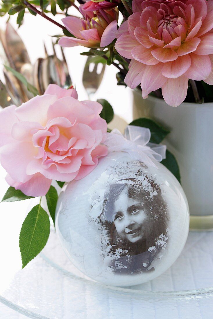 Nostalgic arrangement of snow globe and roses on table