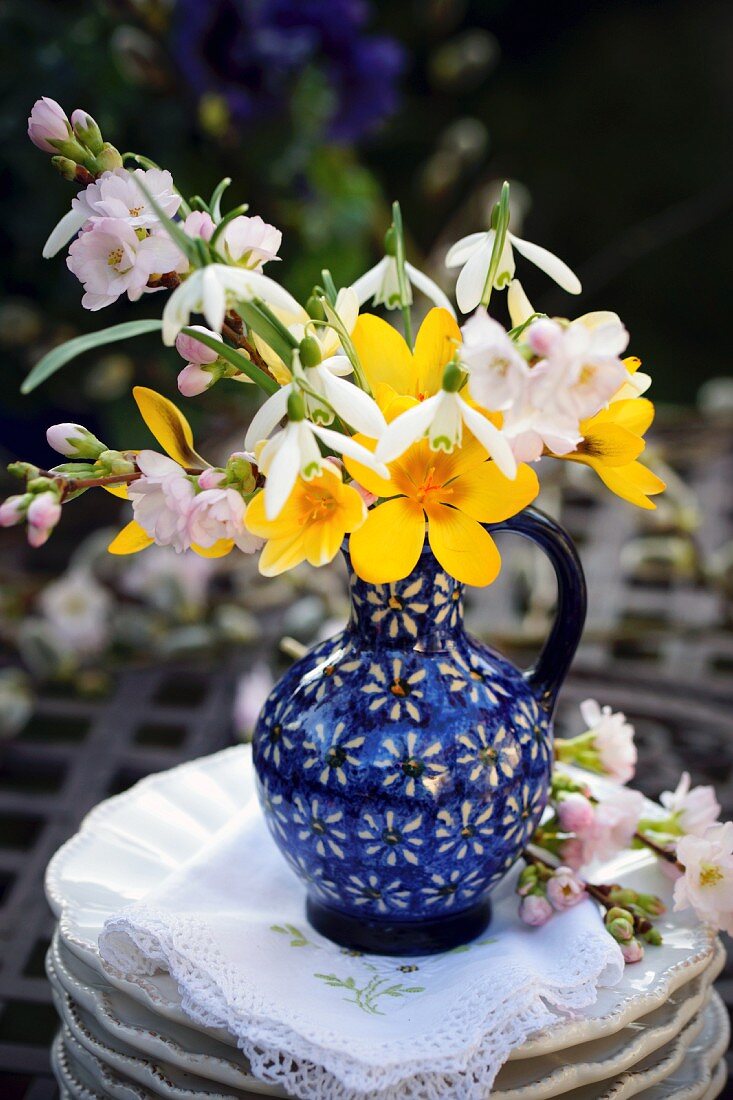 Frühlingsstrauss in blauer Vase mit Kirschblüten, Krokussen & Schneeglöckchen