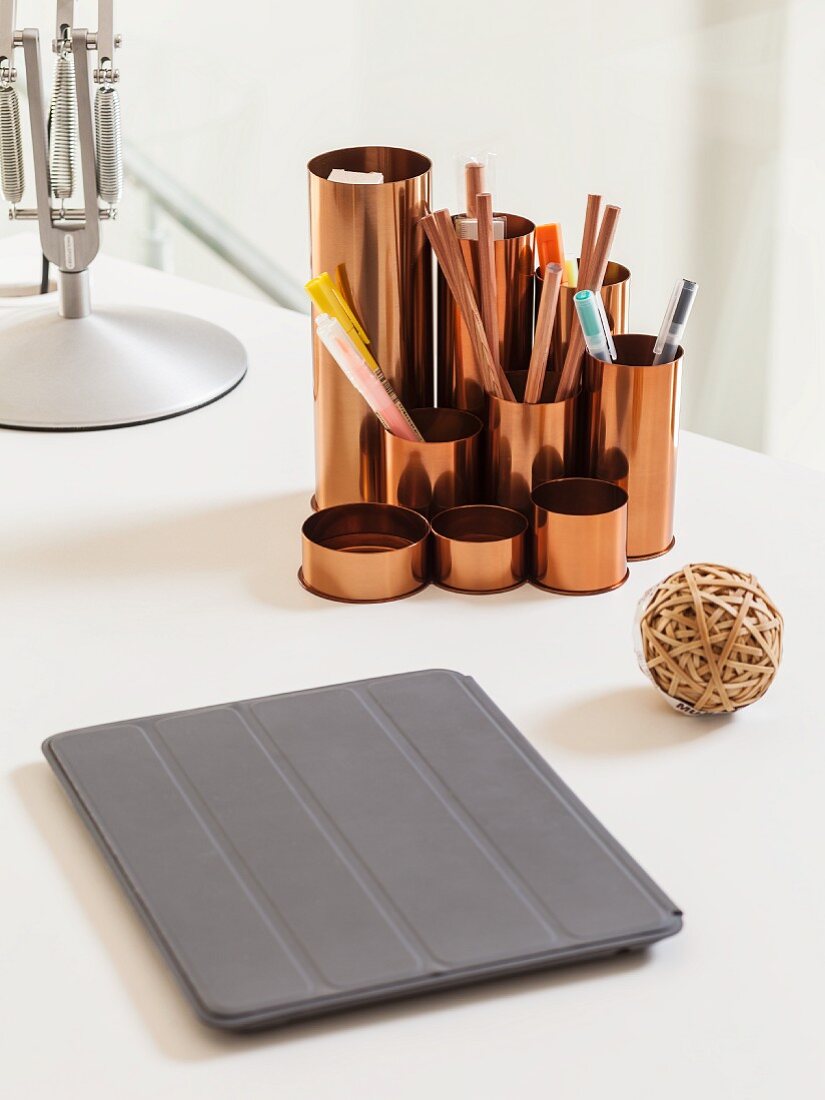 Tablet-PC mit grauer Schutzhülle und kupferfarbener Stiftebehälter