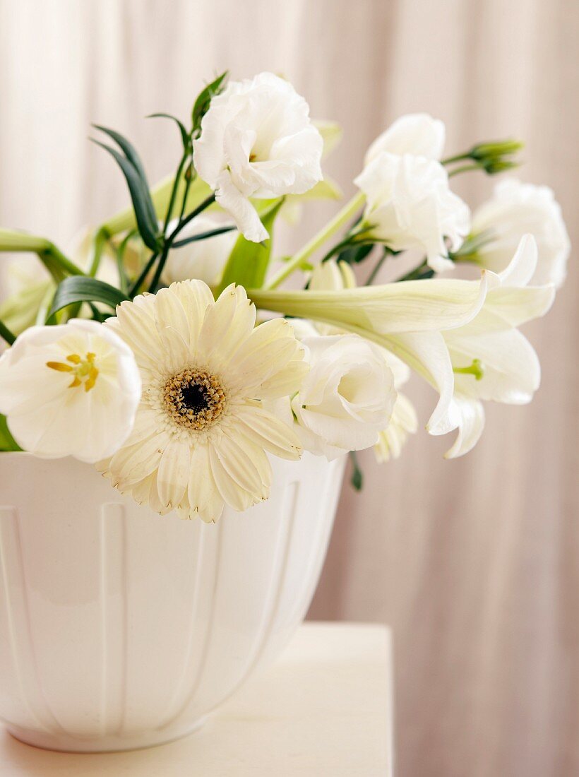 weiße Blüten (Lisianthus, Gerbera, Lilie) in Keramiktopf