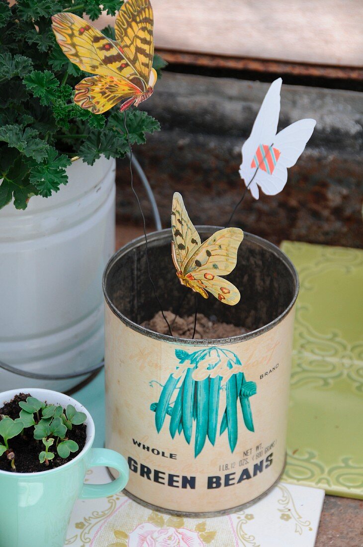 Mit Masking Tape auf Draht geklebte Papier-Schmetterlinge als Deko in Vintage Konservendose