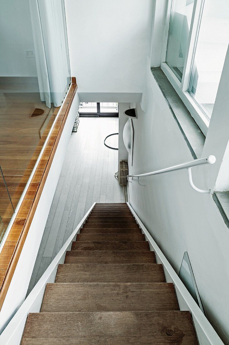 View down narrow staircase with wooden treads