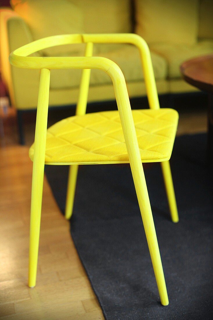 Leuchtgelber Stuhl mit dünn gepolsterter Sitzfläche