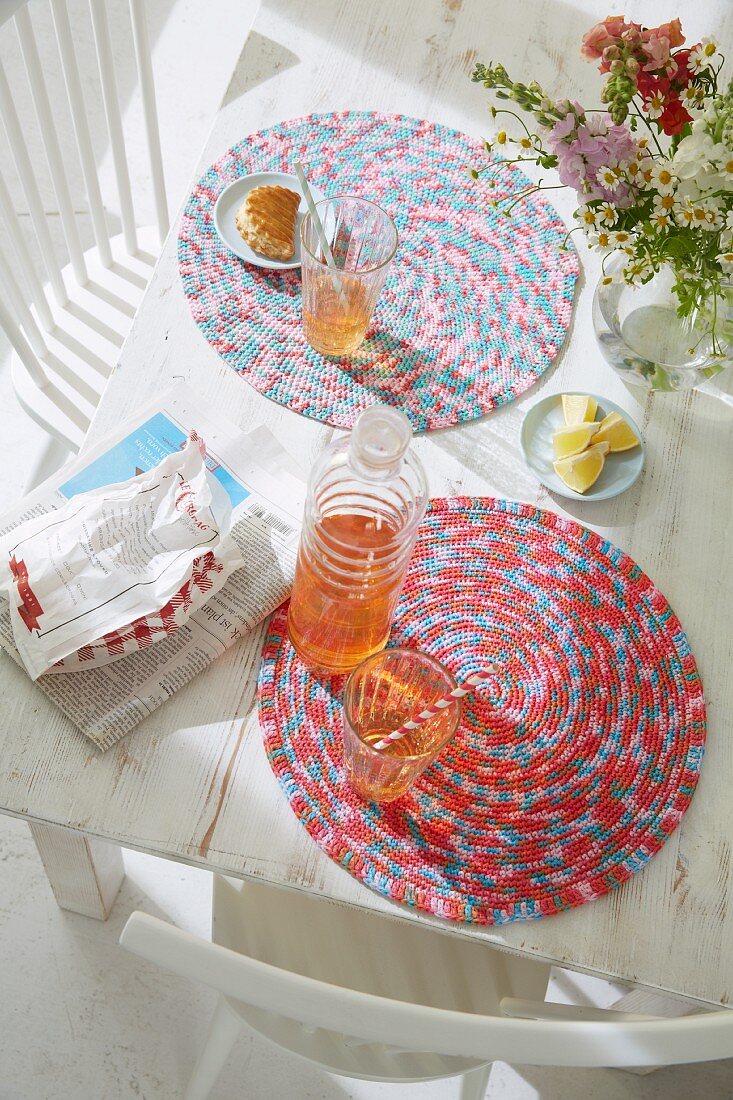 Refreshing drinks on crocheted table mats made from the melange yarn on a white table