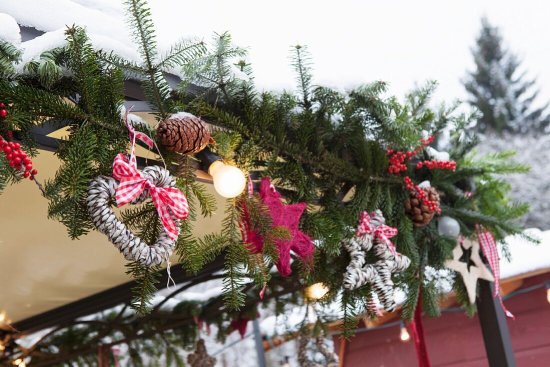 Garland of fir branches and festive ornaments on porch
