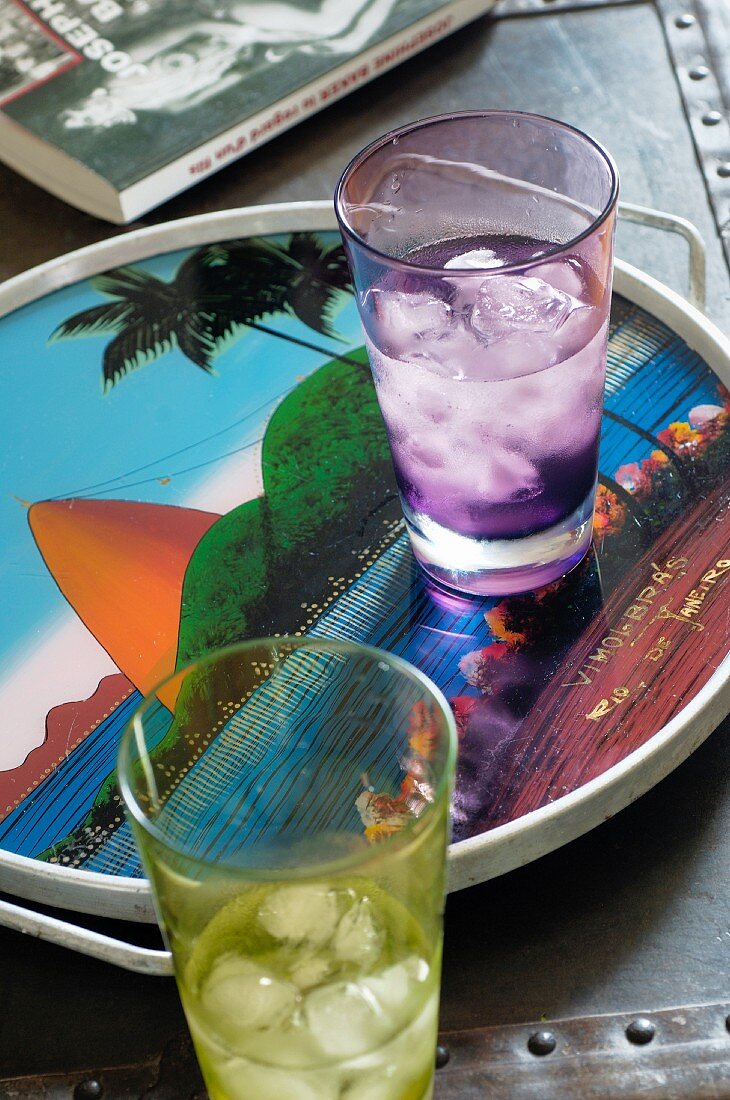 Farbige Trinkgläser mit Wasser und Eiswürfeln auf Tablett, darauf Abbildung vom Zuckerhut, Rio de Janeiro