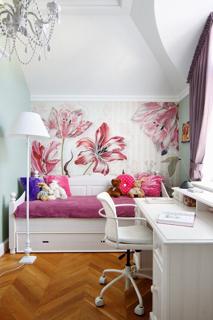White desk and soft toys on daybed against floral wallpaper in white, girl's bedroom