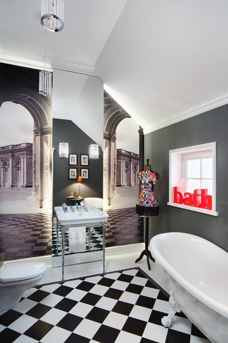 Mit Tapetenbildern antiker Platzfluchten und einem Spiegel optisch vergrössertes Badezimmer; knallroter Schriftzug -bath- als Farbakzent