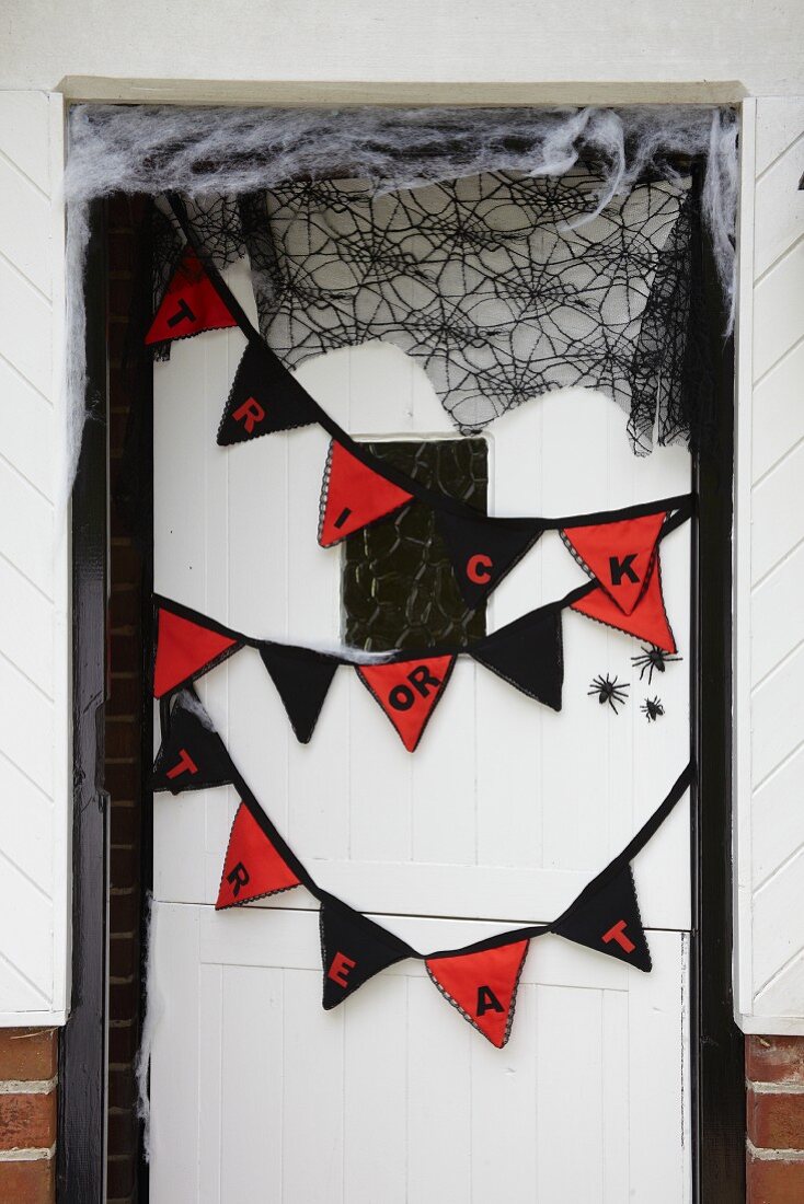 Wimpelkette und Spinnennetz als Halloween Dekoration an Haustür