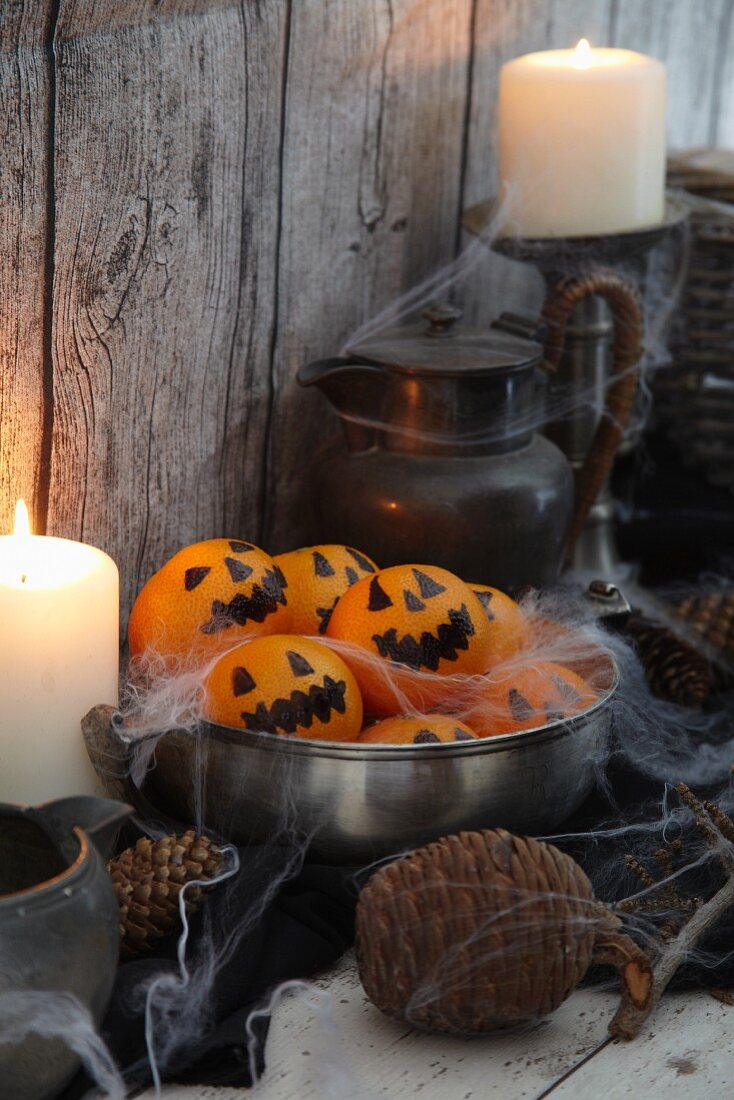 Tangerines decorated with spooky Jack-o'-lantern faces for Halloween