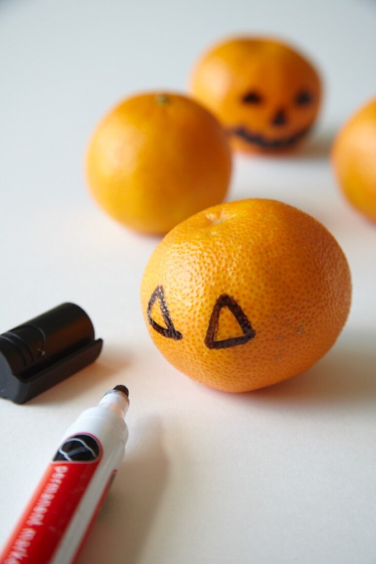 Halloween Dekoration, Gruselgesichter auf Mandarinen malen
