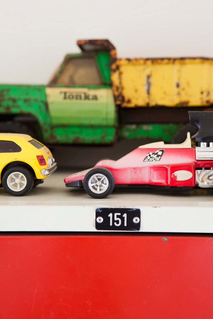 Alte Spielzeugautos auf ausrangiertem Schliessfachschrank