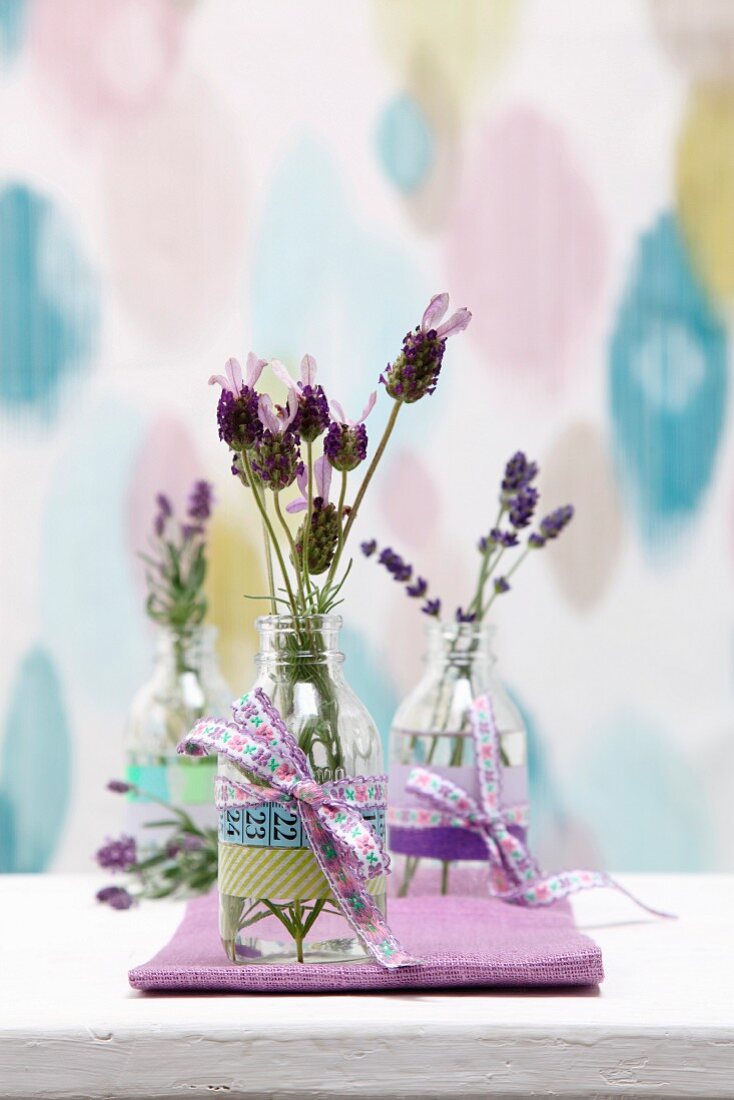 Tischdeko - Lavendelzweige in Glasflaschen mit Schleife und Masking Tape verziert
