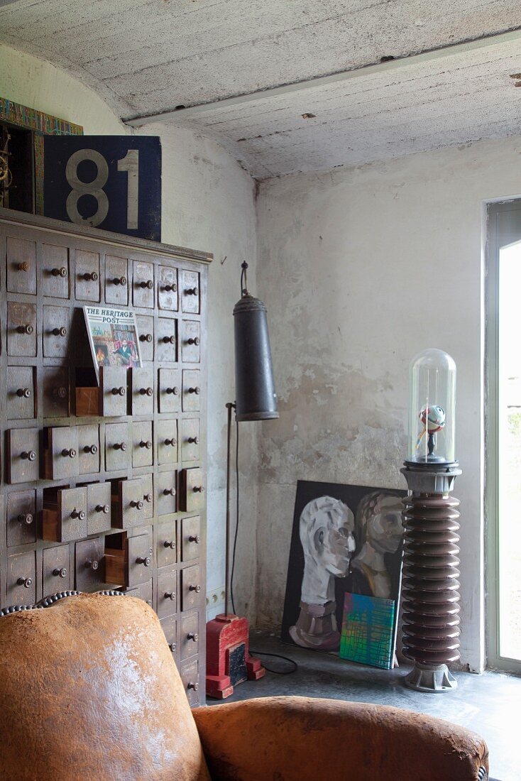 Vintage Ledersessel vor altem Apotheker-Schubladenschrank in Atlierstimmung
