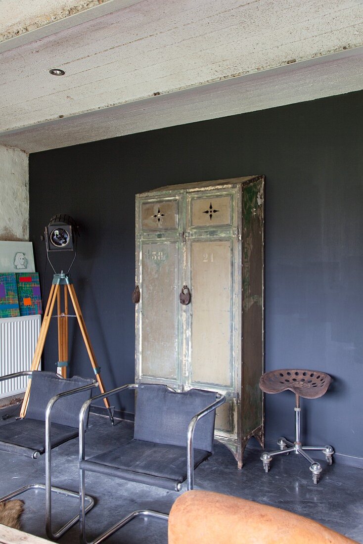 Retro cantilever chairs in front of vintage metal locker against wall painted dark grey