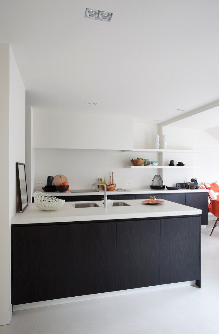 Kitchen counter with dark base units and white worksurface in contemporary kitchen