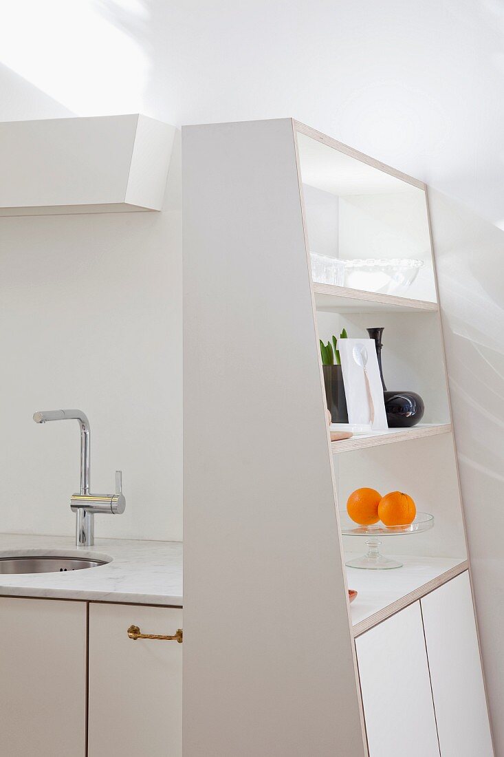 Asymmetrischer weißer Küchenschrank mit offenem Regal an Designerküchenzeile mit Carraramarmor-Küchenarbeitsplatte