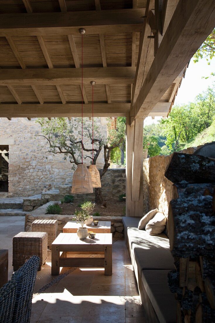 Sitzplatz an Natursteinmauer auf überdachter Terrasse