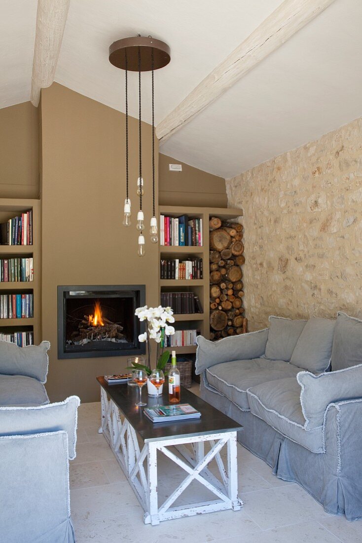 Seating area with loose-covered sofas, coffee table and fireplace flanked by fitted bookcases