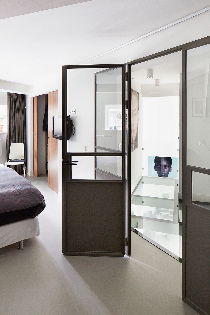 Glass and metal partition element: bed visible to one side