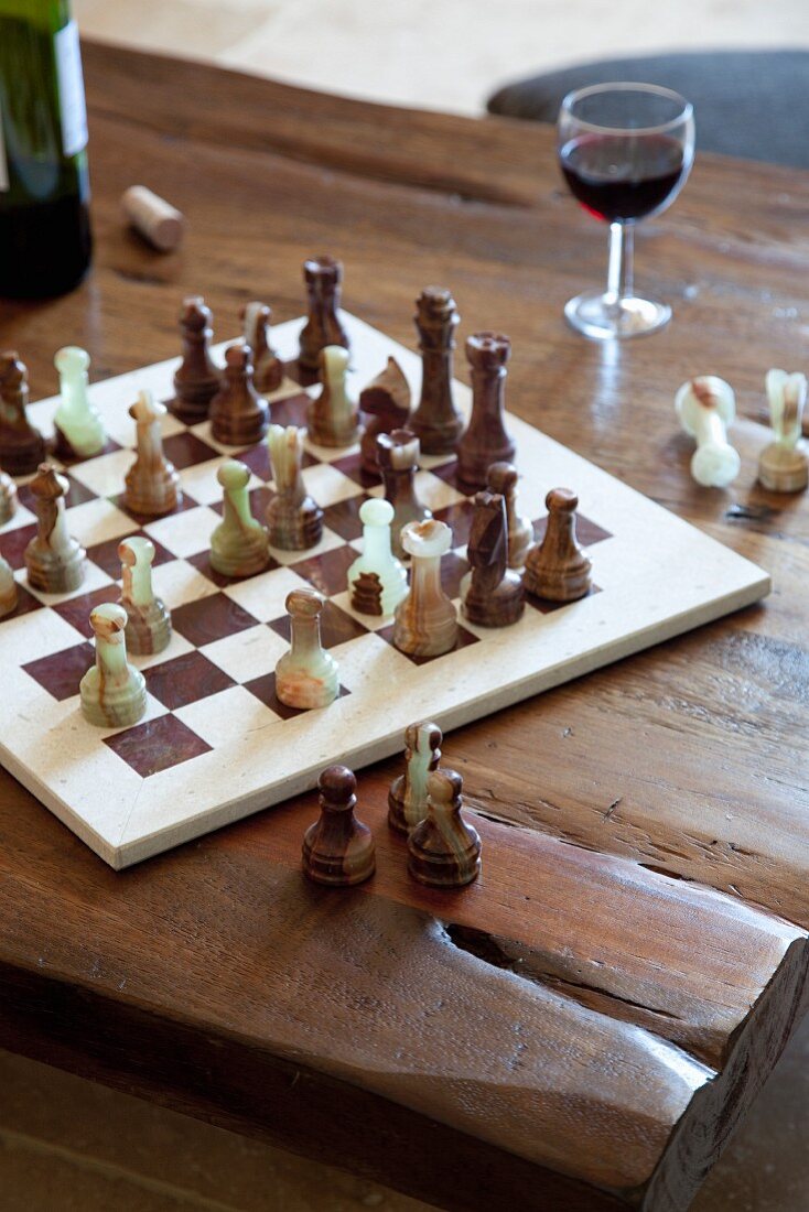 Schachbrettspiel mit Figuren auf rustikalem Holztisch