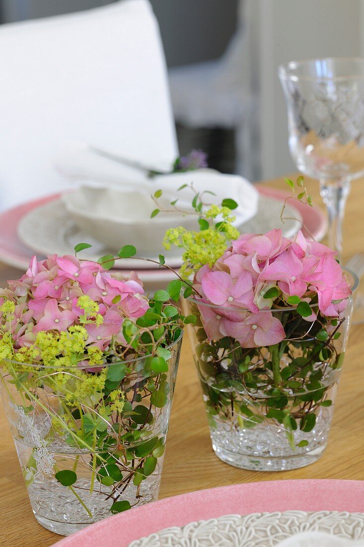 Posies in drinking glasses decorating table