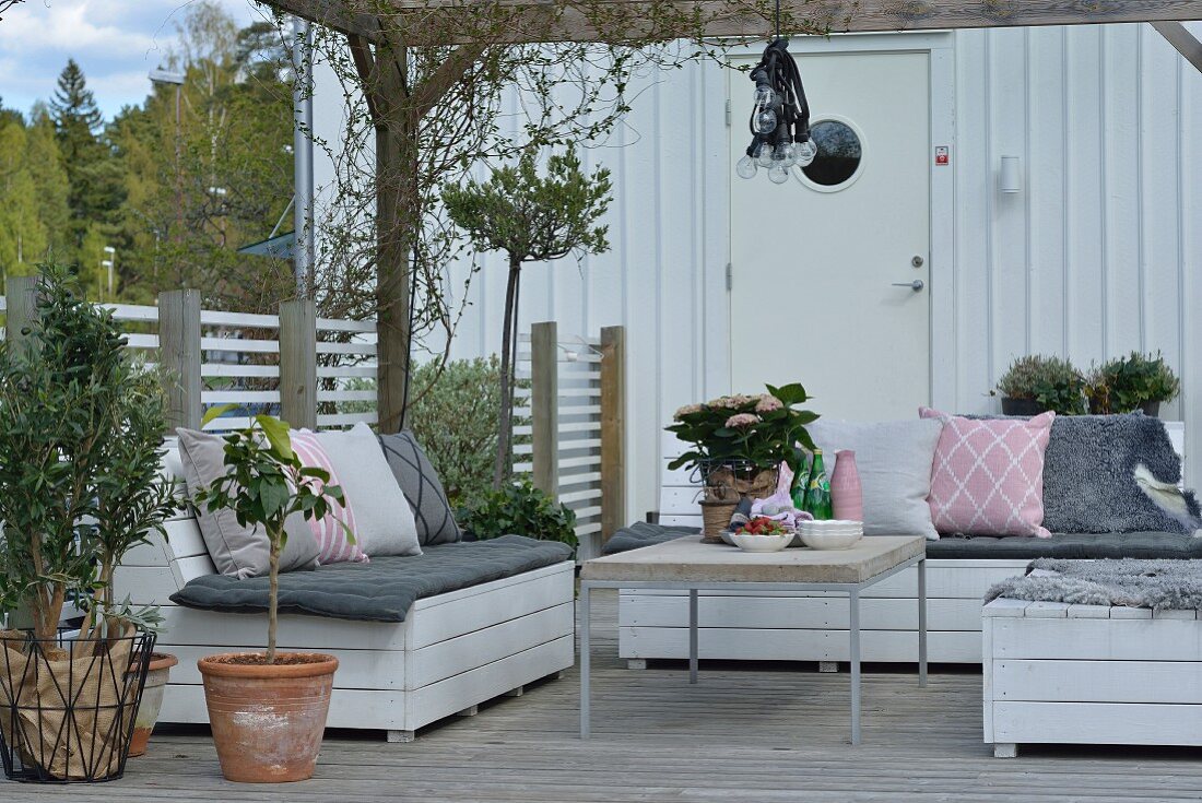 Gemütlicher Terrassenplatz mit selbstgebauten Outdoormöbeln in skandinavischem Ambiente