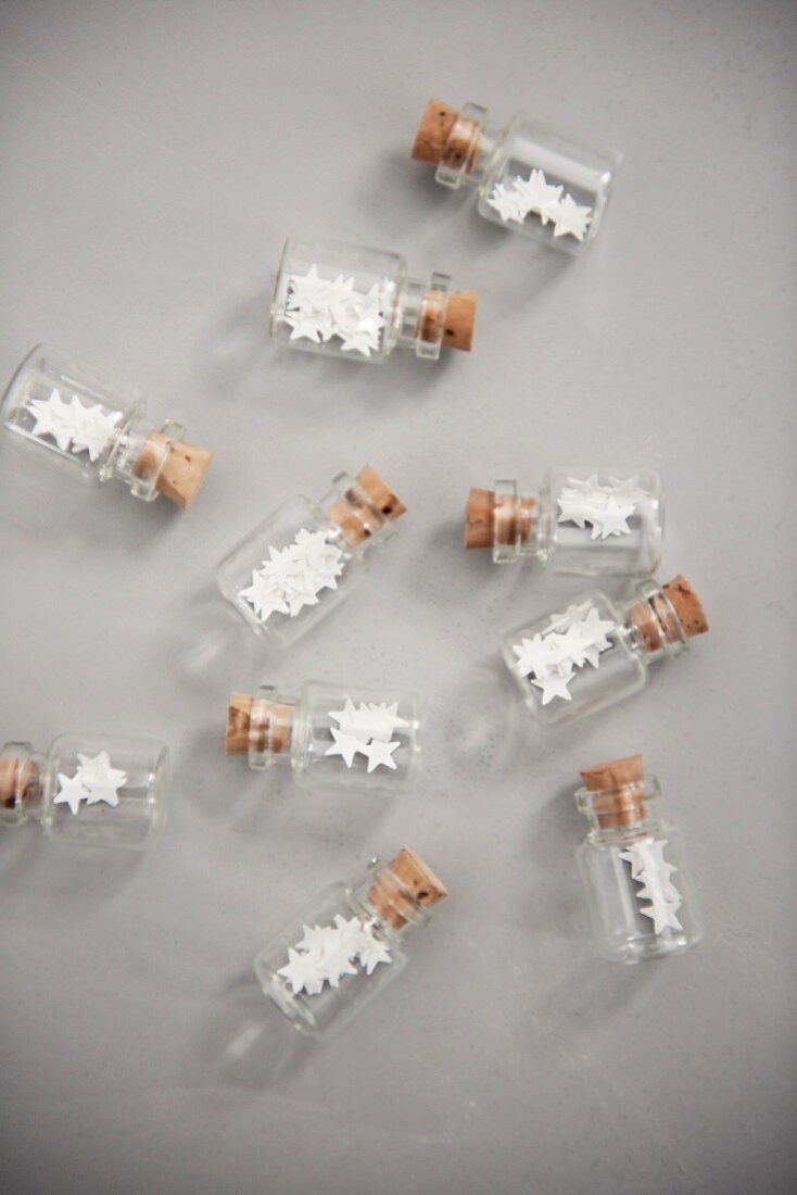 Punched paper stars in small decorative bottles with cork stoppers