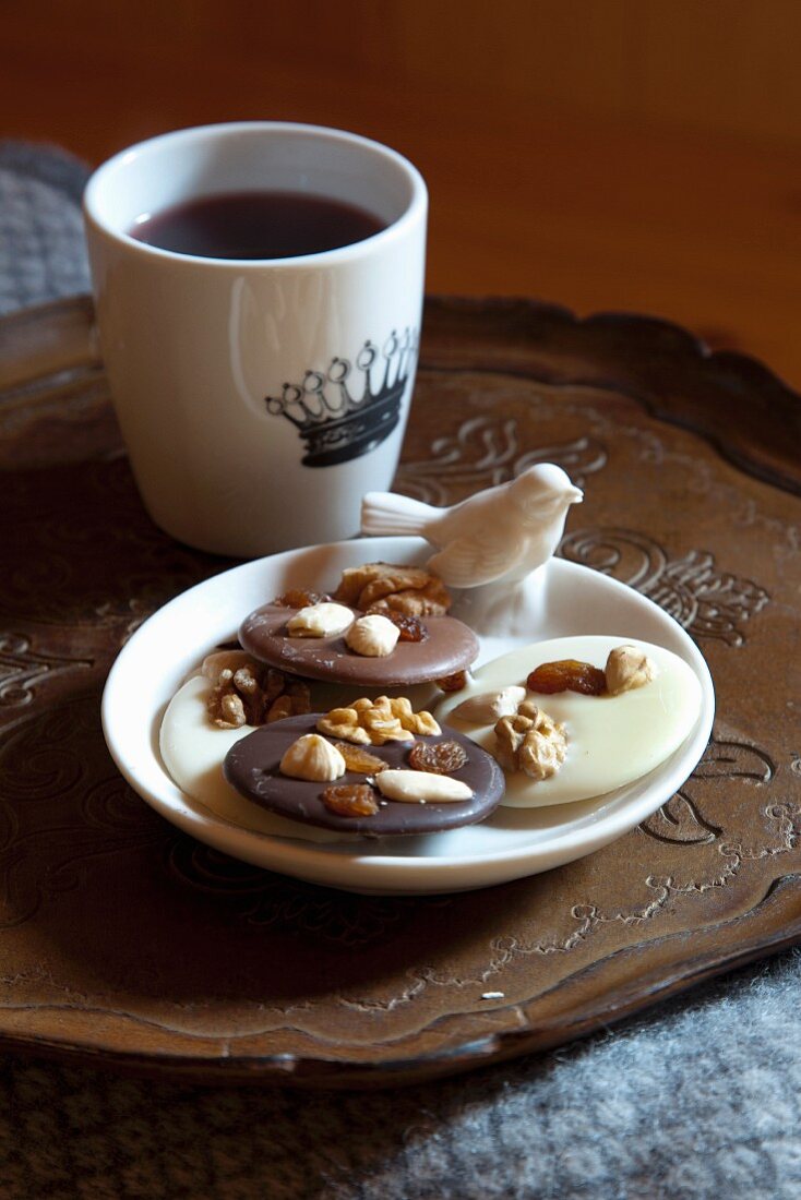 Plate of biscuits with china bird and mug of coffee on vintage tray