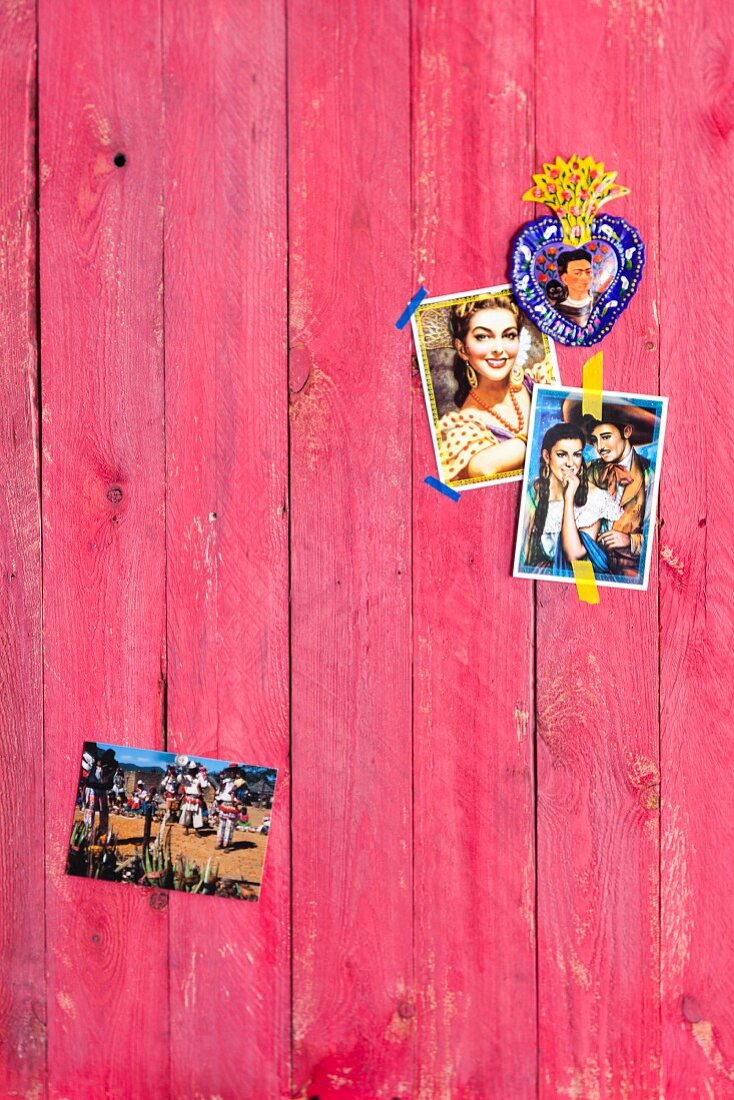 Old Mexican photos on wooden wall painted red