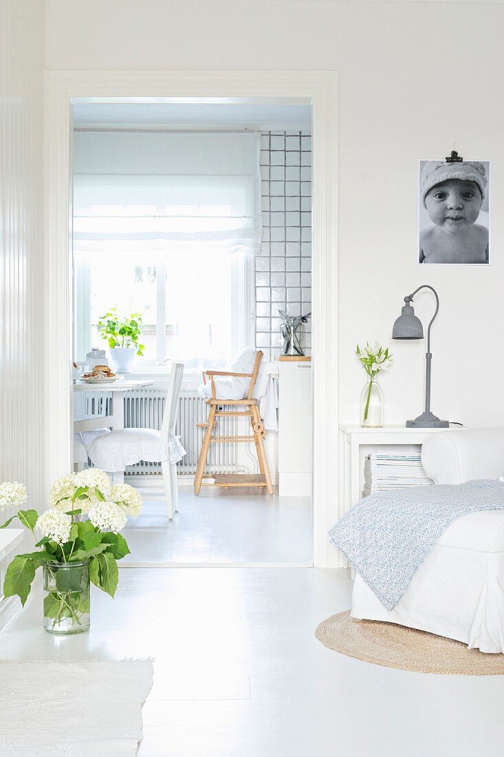 Weisses Wohnzimmer in Shabby Stil, Blick durch Türöffnung auf Essplatz in der Wohnküche