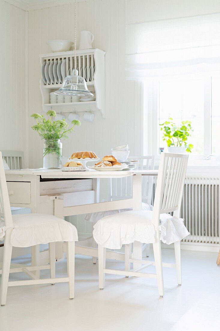Weiß lackierte Holzmöbel am Shabby Essplatz in der Wohnküche