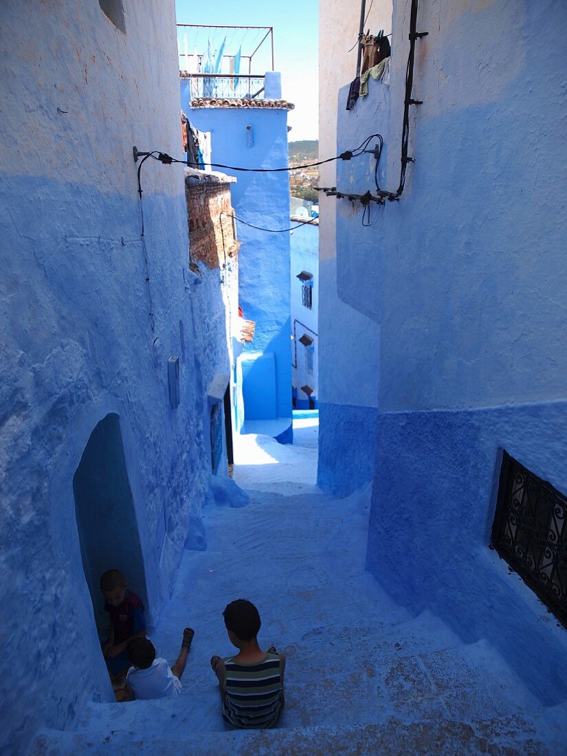 Kinder in einer blauen Gasse in der Medina von Chefchaouen, Marokko