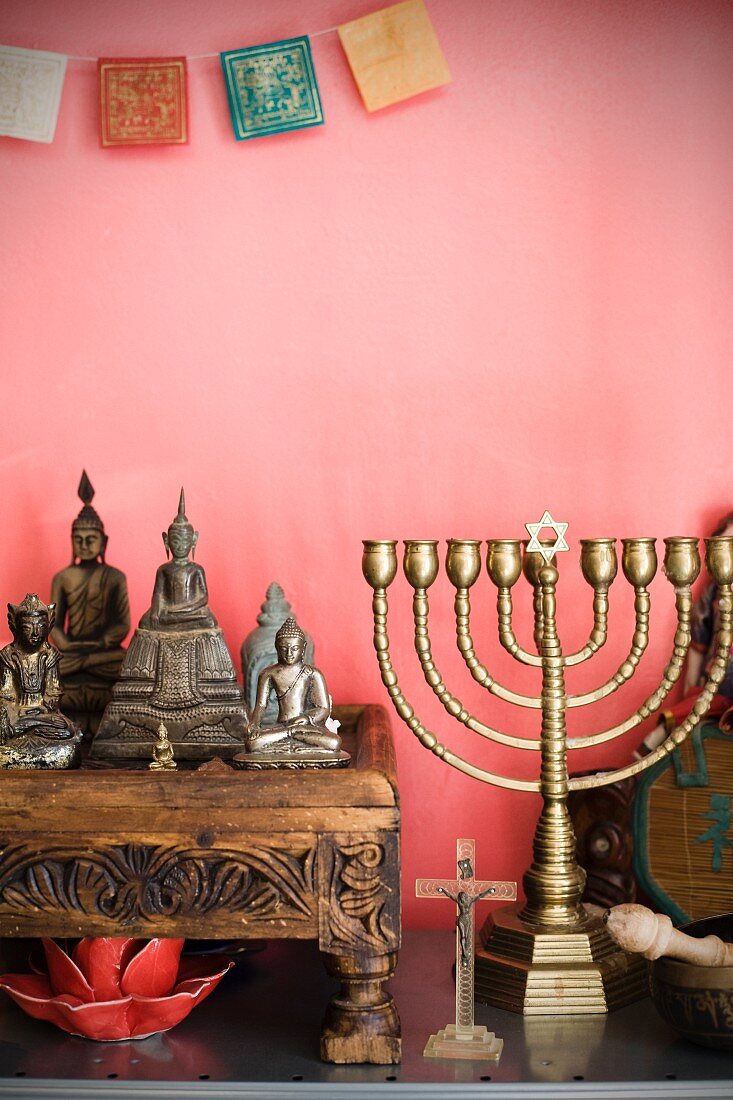 Collection of various religious symbols against pink wall