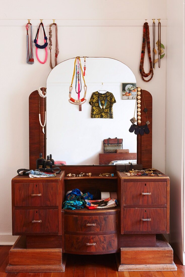 Retro Schminkkommode mit Segmentbogenspiegel, dekoriert mit Halsketten, Seidentüchern, Schmuck und Damenaccessoires