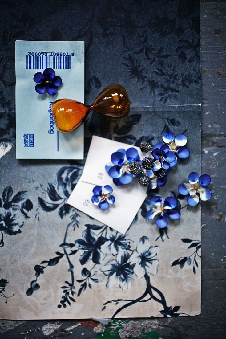 Blue-dyed paper flowers lying on floral paper
