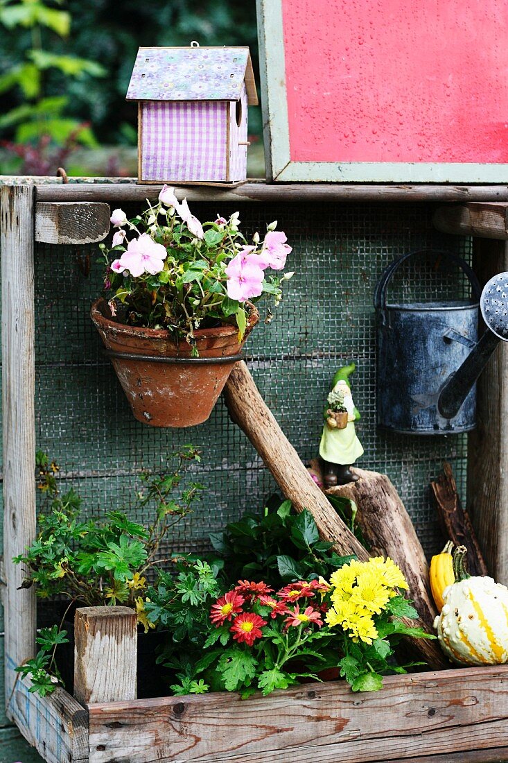 Potting table decorated with flowers, watering can & nesting box
