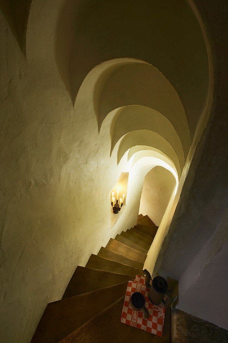 View down steep stone stairs with stepped, arched ceiling