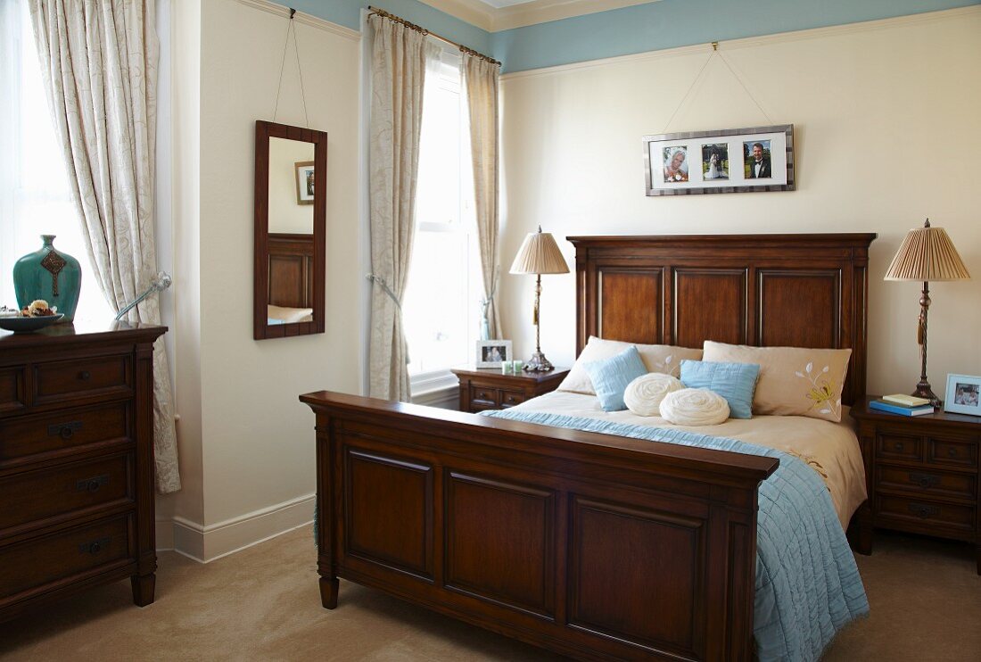Traditionelles Schlafzimmer mit Accessoires und Wandfries in Hellblau zu dunklen Holzmöbeln