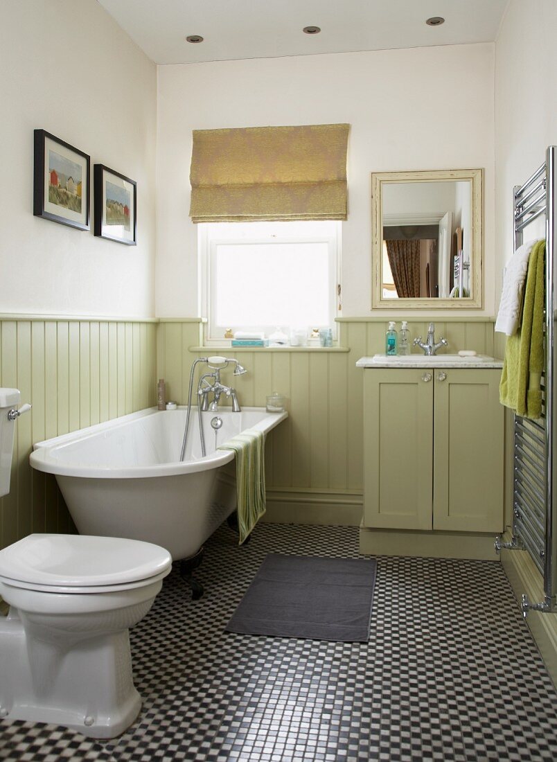 Traditional, country-house-style bathroom with pale green wainscoting and mosaic-tiled floor with small, chequered pattern