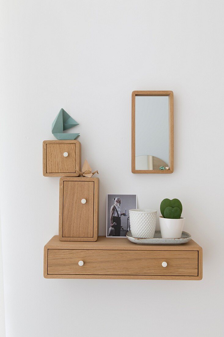 Holzkästchen in verschiedenen Formaten um Spiegel an Wand aufgehängt